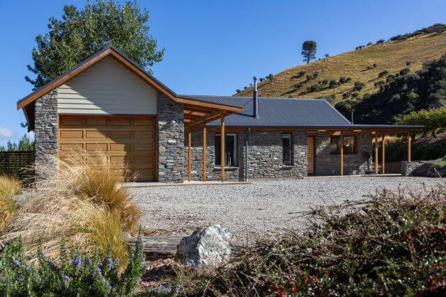 1. Stone cottage at Judge & Jury Village in New Zealand, surrounded by greenery and scenic landscapes, perfect for unique accommodations in North Island.