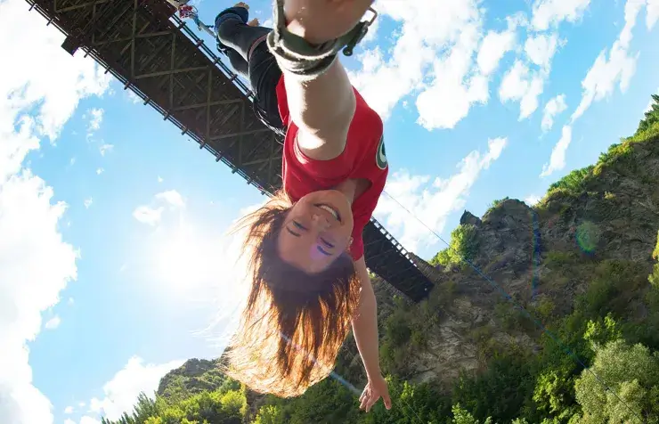 Thrilling bungee jump from Judge & Jury Village suspension bridge, with scenic mountains and clear blue sky, offering adventurous experiences in New Zealand's outdoor activity destination.