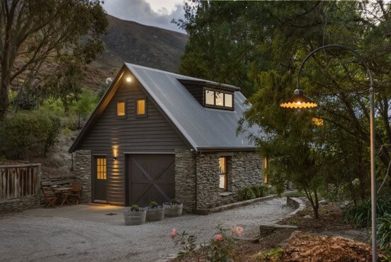 Cozy barn-style accommodation at Judge & Jury Village, surrounded by lush greenery and mountain views, ideal for rural getaways and outdoor adventures.